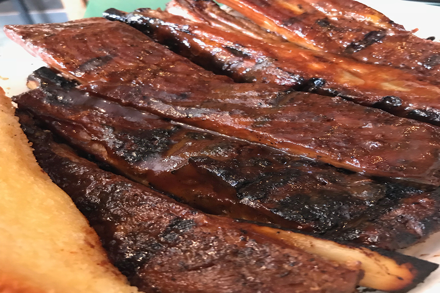 White plate topped with barbecued spare ribs and french fries